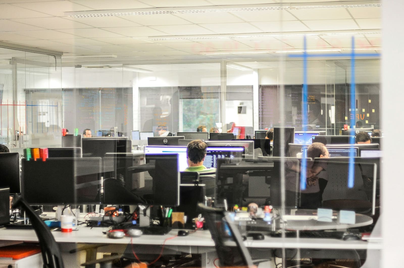 Engineers working together at desktop computers in an office