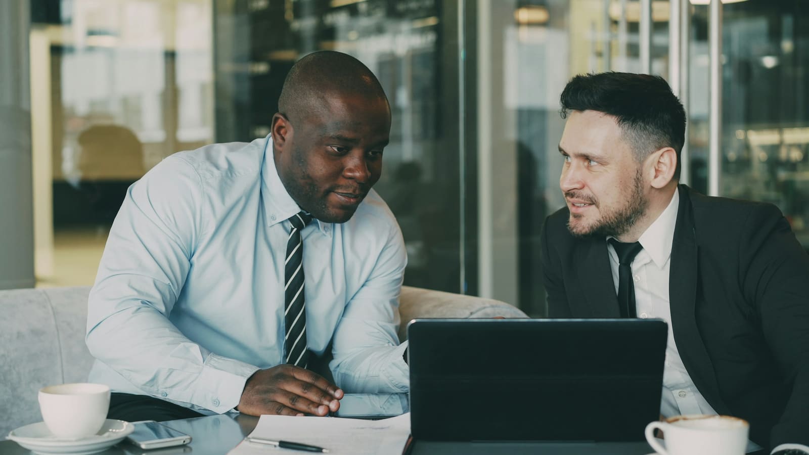 Two colleagues discussing documents at a table
