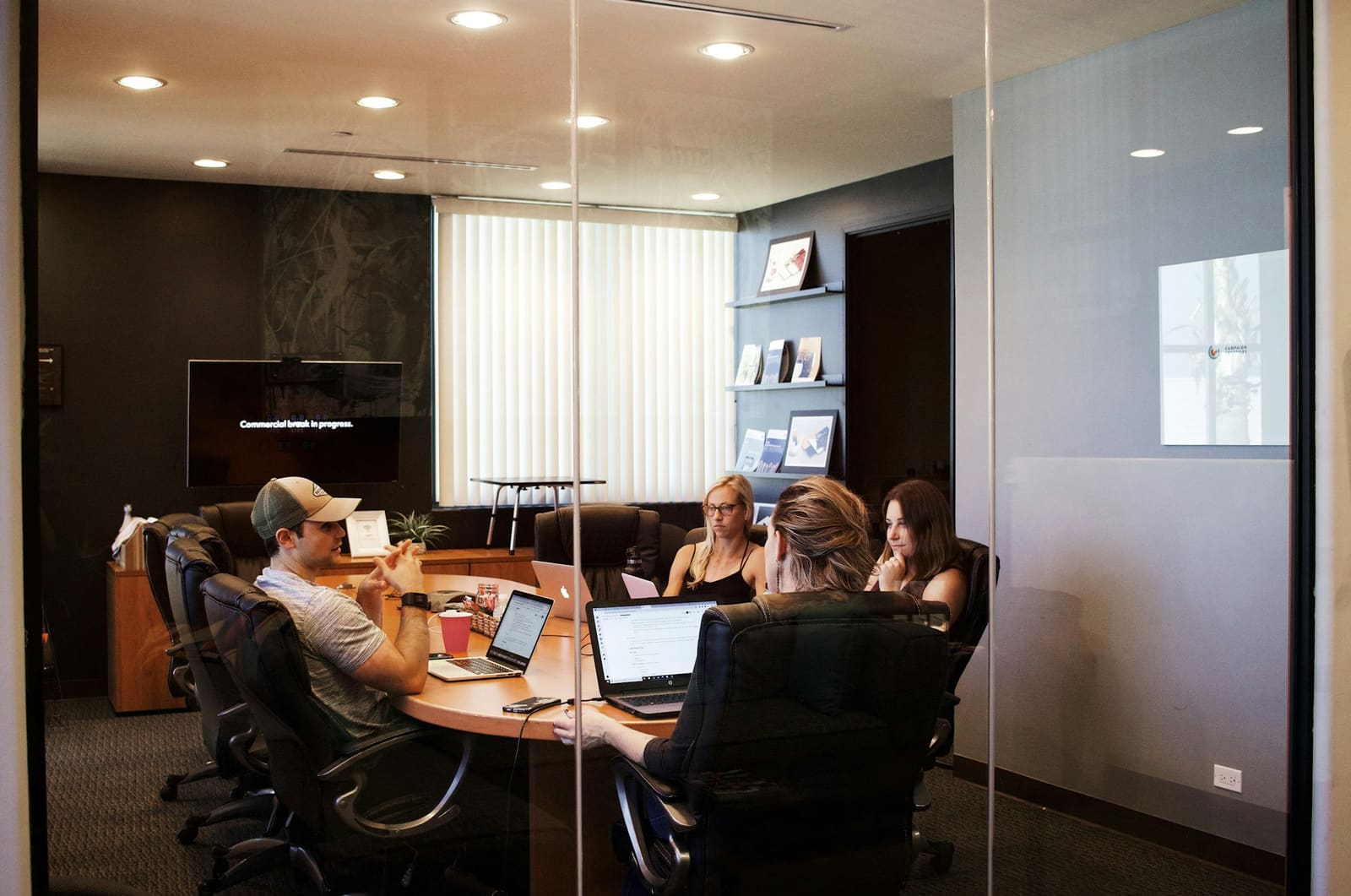 A team gathered around a table with a laptop